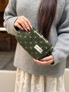 Detail of plush moss green pencil case with soft faux shearling texture and zip closure