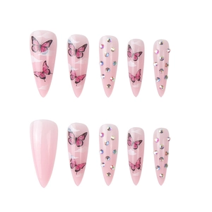 Detail of pink stiletto press-on nails with butterfly patterns and rainbow rhinestones