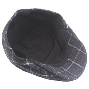 Detail of British plaid flat cap showing wool texture and adjustable snap closure back
