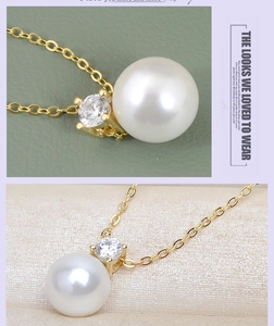 Gros plan du collier avec perle blanche ronde et pendentif en oxyde de zirconium doré