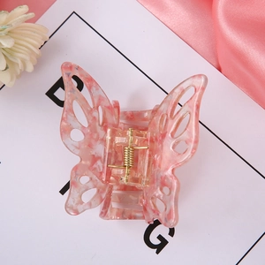 Detail showing pink marble texture acrylic butterfly hair claw clip with golden spring