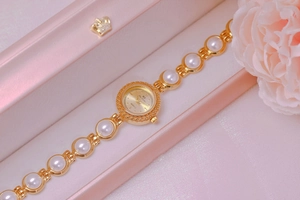 Close-up of pearl luxury quartz watch for women inside a pink crown gift box