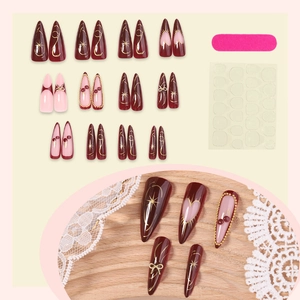 Long stiletto press-on nails set in red and pink with gold bows and heart accents
