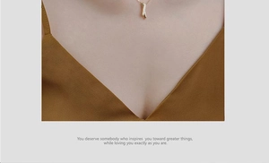 Close-up of a sparkling zircon cross pendant on a gold necklace worn by a model