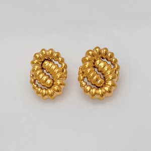 Detail of vintage 18k gold plated twisted rope hoop earrings with metallic texture