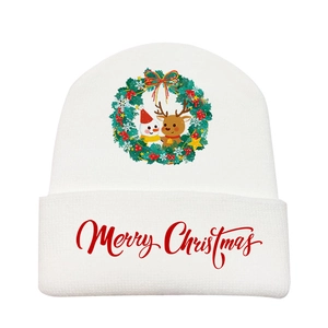 Detail of white knitted Christmas beanie with festive wreath and reindeer print