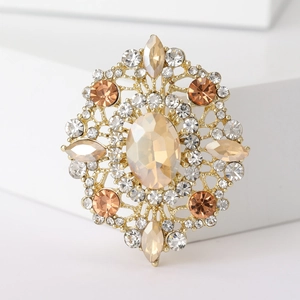 Detailed close-up of champagne crystal oval brooch with gold metal floral setting