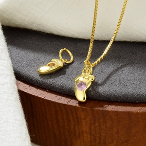 Goldene Halskette mit Babyfuß-Anhängern und einem rosa Zirkonia-Stein-Akzent