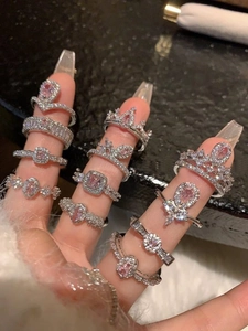 Gedetailleerd beeld van zilveren ringen met heldere en roze edelstenen in diverse ontwerpen