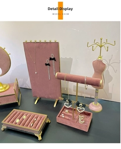 Detailed display of pearl bow earrings and gold necklaces on velvet jewelry stands