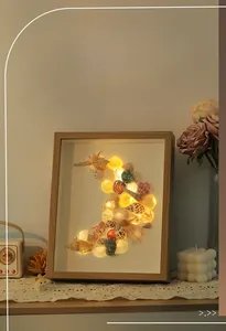 Macro detail of handmade shell art photo frame with warm LED lights and pearls