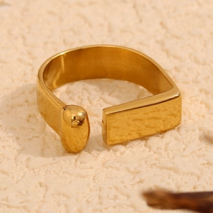Macro detail of 18K gold plated open ring with lava hammer texture and geometric ends