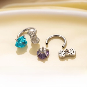 Macro detail of titanium steel horseshoe ring with blue heart zircon and bowknot charm
