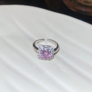 Detail view of pink zircon ring with halo crystals and silver finish on a ceramic tray