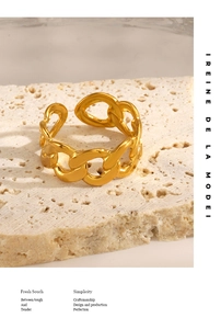 Gros plan d'une bague chaîne plaquée or 18 carats sur une surface en pierre naturelle