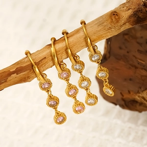 Vintage gold titanium steel earrings with pink and white zircon stones on wood branch