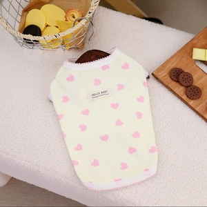Detail of pet vest showing pink heart patterns, lace trim, and Hello Baby woven label