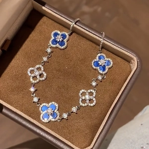 Elegant silver-toned clover bracelet with blue enamel and sparkling cubic zirconia floral link