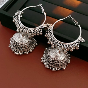 Detailed close-up of silver Jhumka style hoop earrings with ornate bell-shaped charms