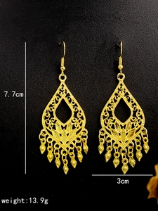 Macro detail of bohemian gold peacock earrings with tassel length and weight measurements