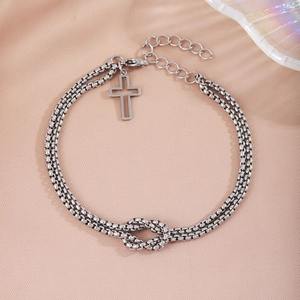 Silver double-layer chain bracelet featuring knot detail and a cross charm on silk
