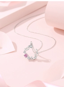 Macro detail of S925 silver necklace featuring a wreath pendant with pink and white zircon stones