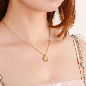 Elegant gold titanium steel necklace with Roman numeral pendant worn by a model