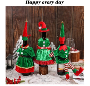 Detail of Christmas elf wine bottle covers in red and green velvet on a festive table