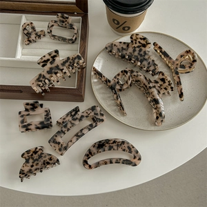 Collection of light leopard print acetate hair claws and clips in a stylish arrangement