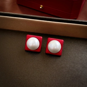 Macro shot of red square earrings with white pearls featuring matte finish and elegant style