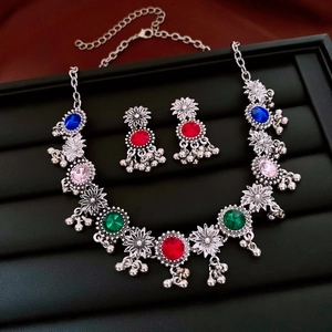 Detailed macro view of bohemian silver necklace and earrings with multicolor gemstones