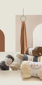 Detail of rolled double-sided fiber fleece blankets in beige, grey and brown colors