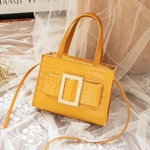 Elegant yellow crocodile pattern handbag featuring a large square golden buckle detail