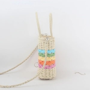 Macro detail of rainbow striped woven straw bag with adjustable shoulder strap