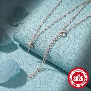 Minimalist 925 sterling silver cross pendant necklace on light blue background