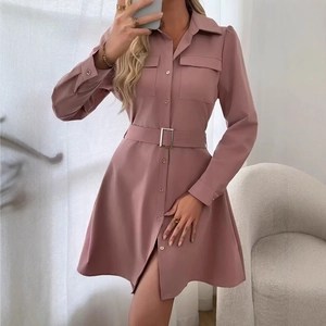 Detail of elegant dusty pink shirt dress featuring front pockets and a buckled waist belt