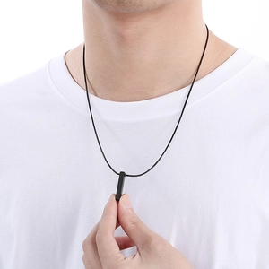 Close-up of model wearing black rectangular geometric pendant on a fine black steel chain