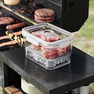 Portable transparent bento box with drain tray and vent on an outdoor grill table