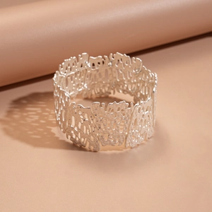 Macro detail of silver irregular cutout floral bracelet with matte lava texture finish
