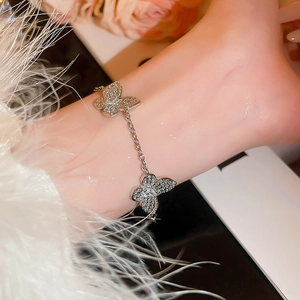 Detail of silver double butterfly bracelet with sparkling zircon stones on a wrist