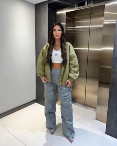 Style streetwear avec veste bomber vert armée, pantalon cargo gris et crop top blanc