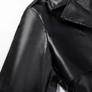 Detail of lapel collar and shoulder stitching on a long black faux leather coat for women