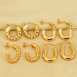 Set of four gold-plated twisted spiral geometric hoop earrings on satin fabric