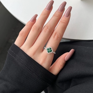 Close-up of S925 sterling silver four-leaf clover ring with green zircons on model hand