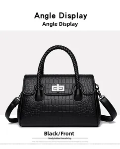 Détail du sac à main noir en similicuir avec motif crocodile et poignée tressée