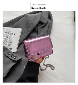 Close-up of rose pink crocodile pattern crossbody bag with shiny metallic finish