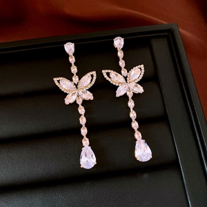 Detail of long heart tassel earrings featuring cubic zirconia butterflies and water drop charms