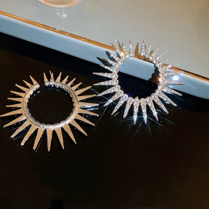 Macro shot of silver sunflower stud earrings with sparkling rhinestones on black surface