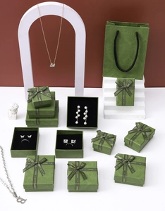 Detail of luxury green patterned jewelry box set with ribbons and swan necklace