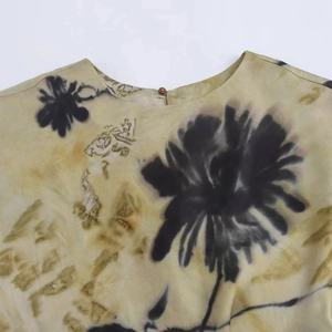 Close-up of elegant silk texture dress with ink floral print and wooden button detail